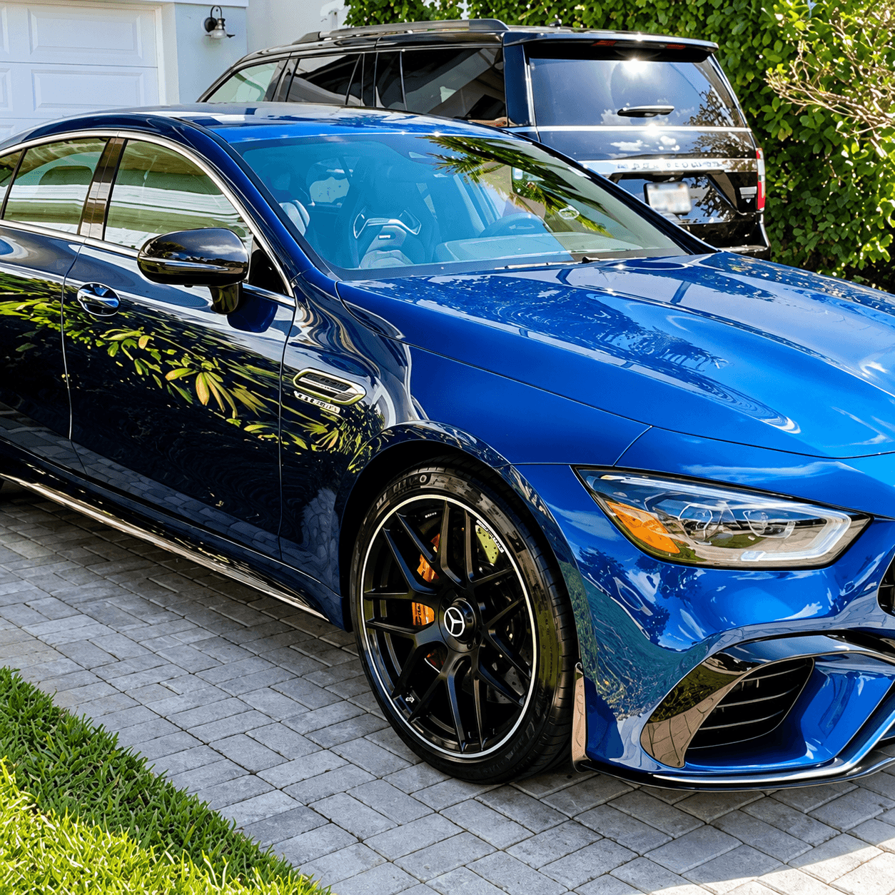 Bright blue Mercedes-AMG sports car parked in residential driveway with black wheels