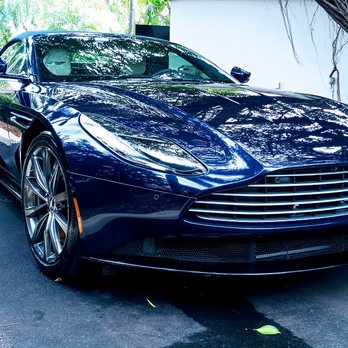 Sleek dark blue sports car with chrome grille parked outdoors