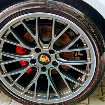 Close-up of silver multi-spoke alloy wheel with red brake calipers and Porsche logo